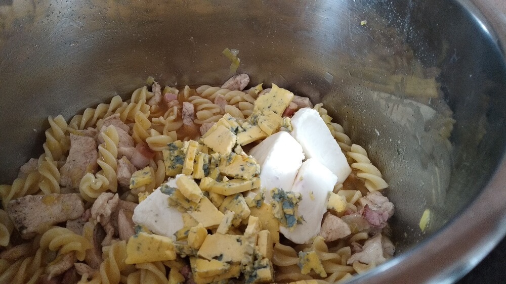 two kinds of cheese added to pasta and meat inside instant pot