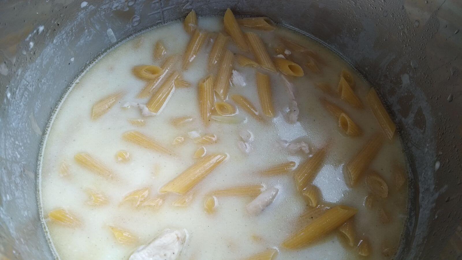 cheese sauce and raw pasta inside instan pot prior to cooking